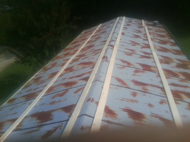 Rusted metal roof panels with new wood purlins before replacement — Storm Damage Roof Repair in Castile by Roofing Brothers