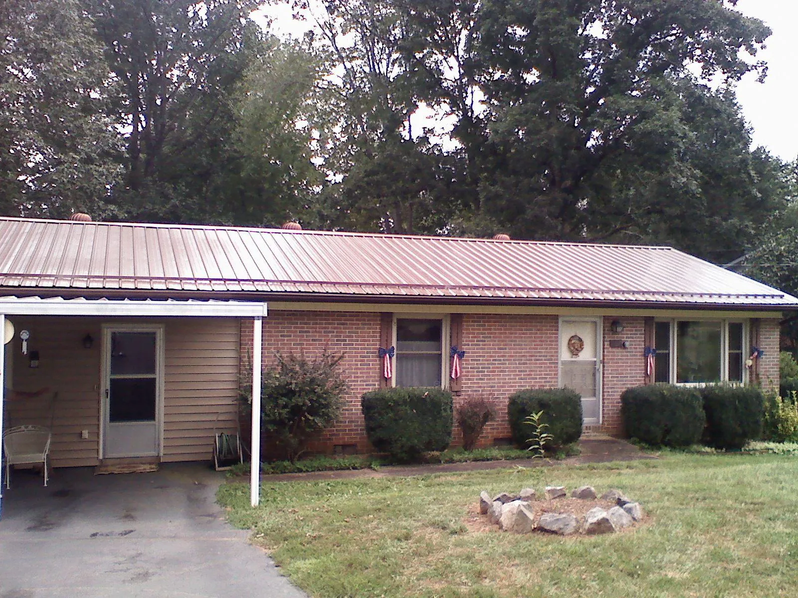 Bronze metal roof and carport on a brick ranch home — Roof Repair work by our crew in Castile
